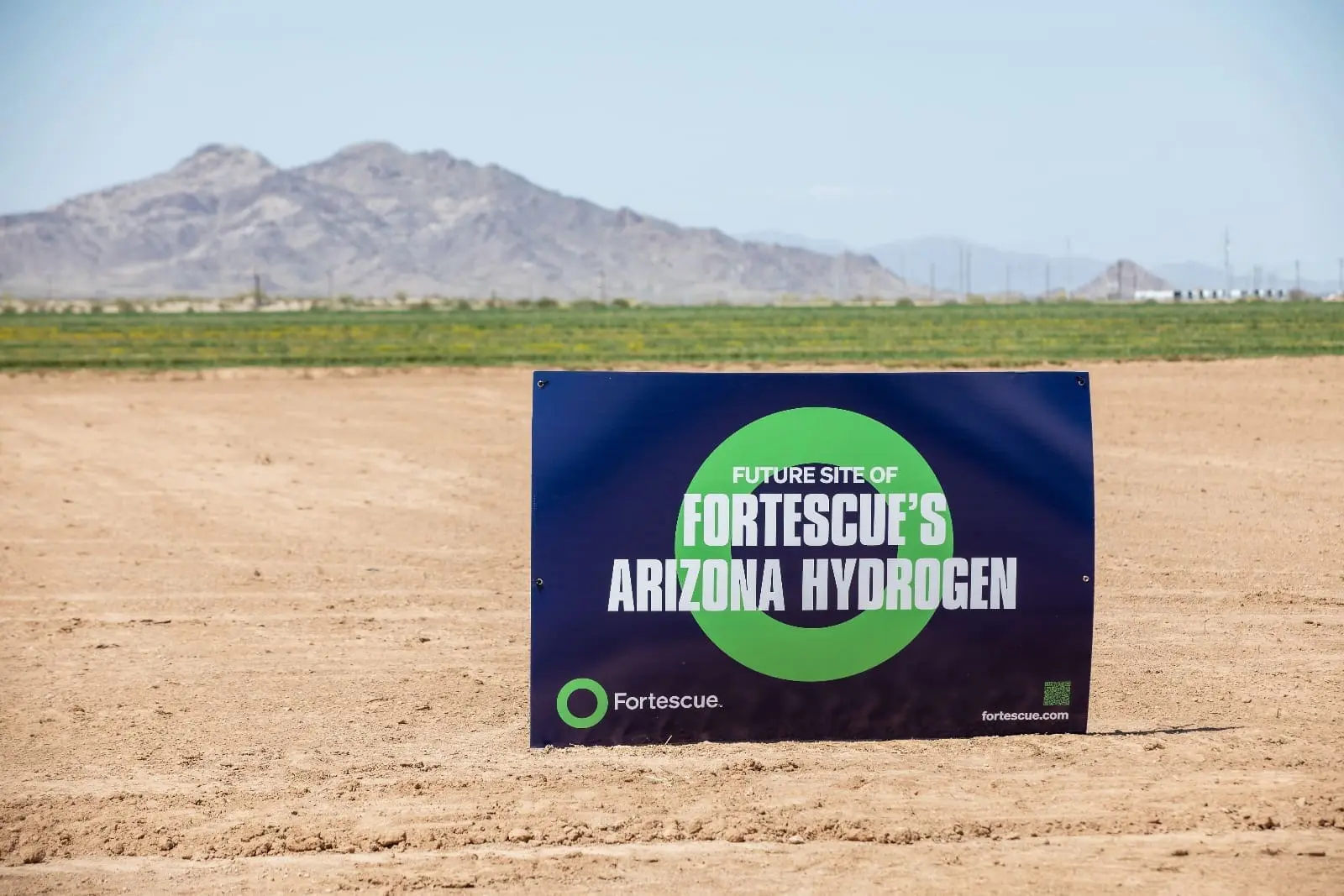 Open dirt field with business sign for Arizona Hydrogen stuck in ground