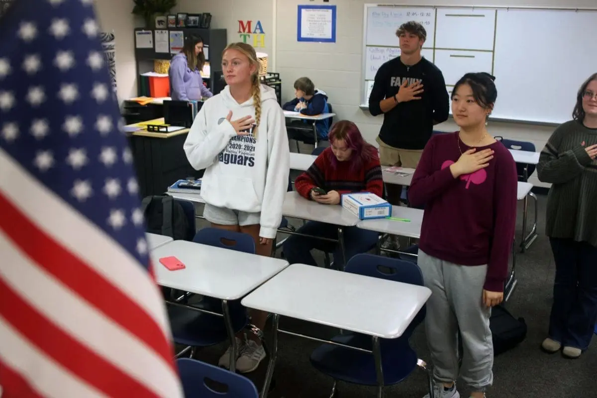 Students reciting the pledge if allegiance in a classroom.