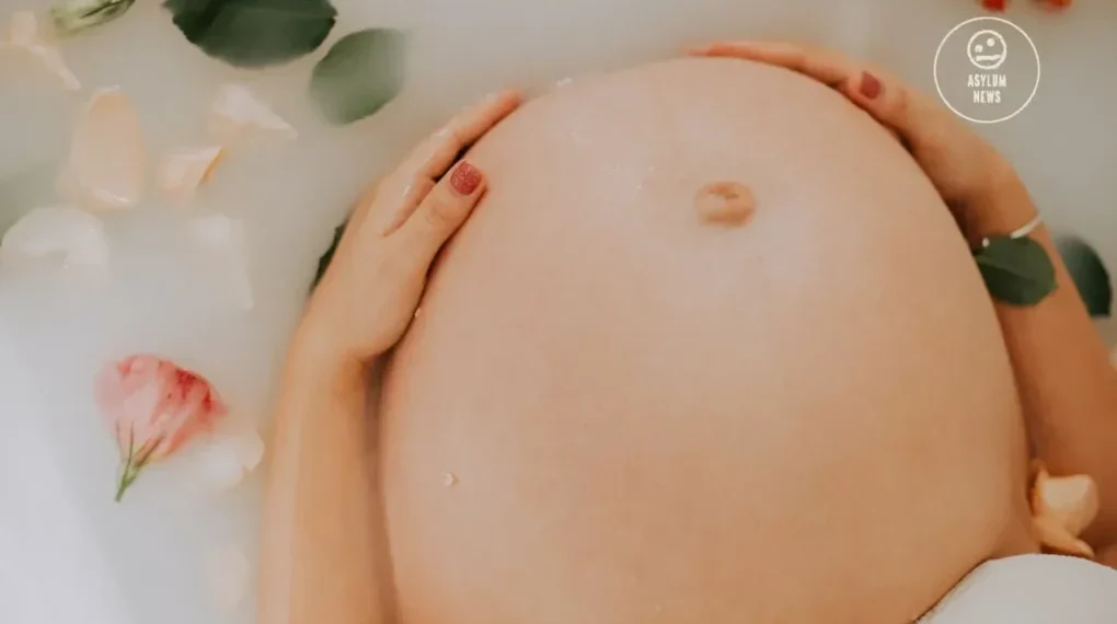 Pregnant woman sitting on bathtub