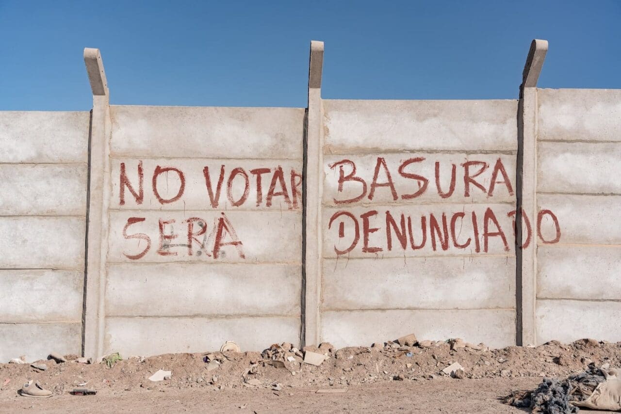 Chile shantytown with graffiti on a wooden fence