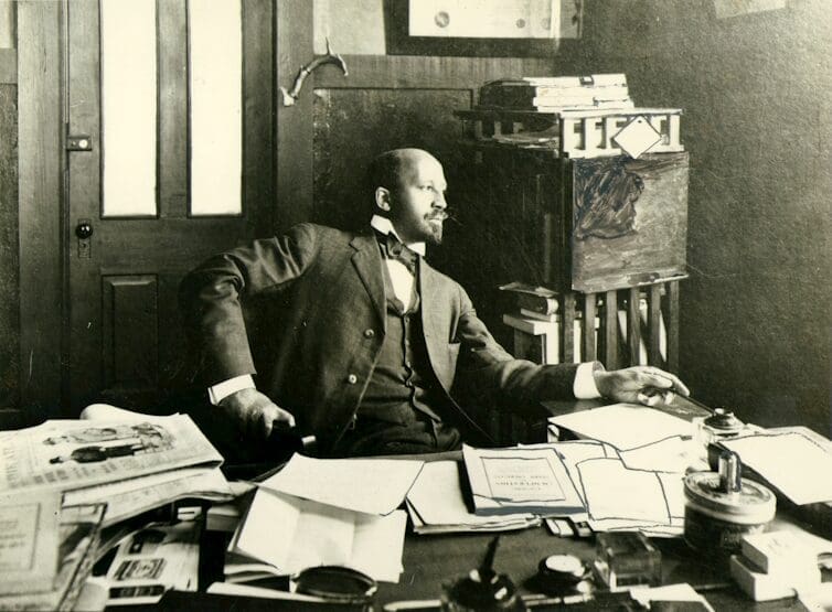 A black and white photograph of W.E.B. Dubois in his office