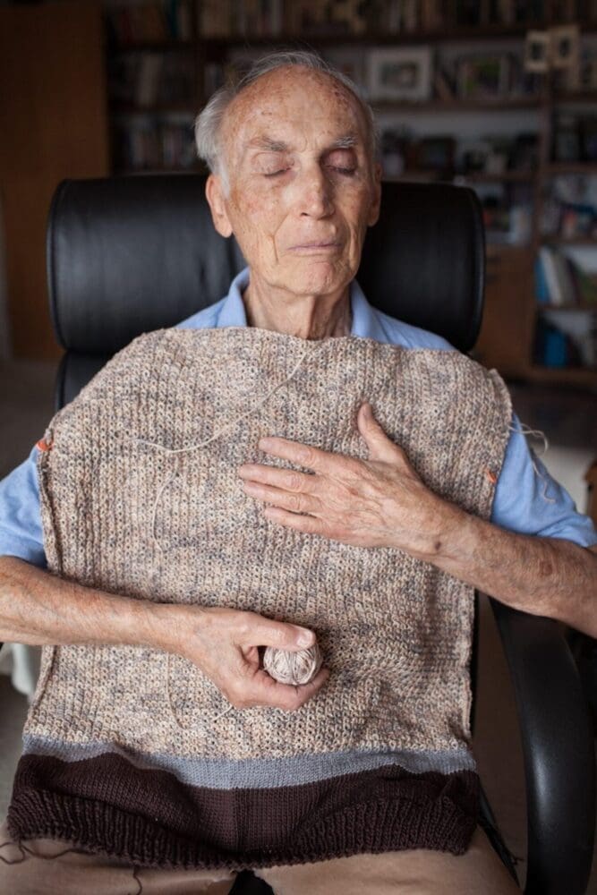 Elderly man with a hand-knitted blanket on his chest