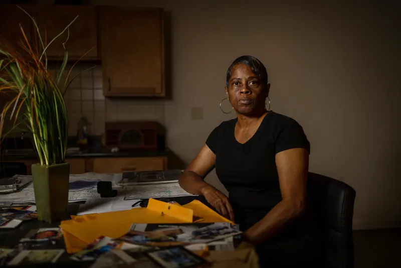 Kentrell Parker’s mother sits at a kitchen table covered in documents