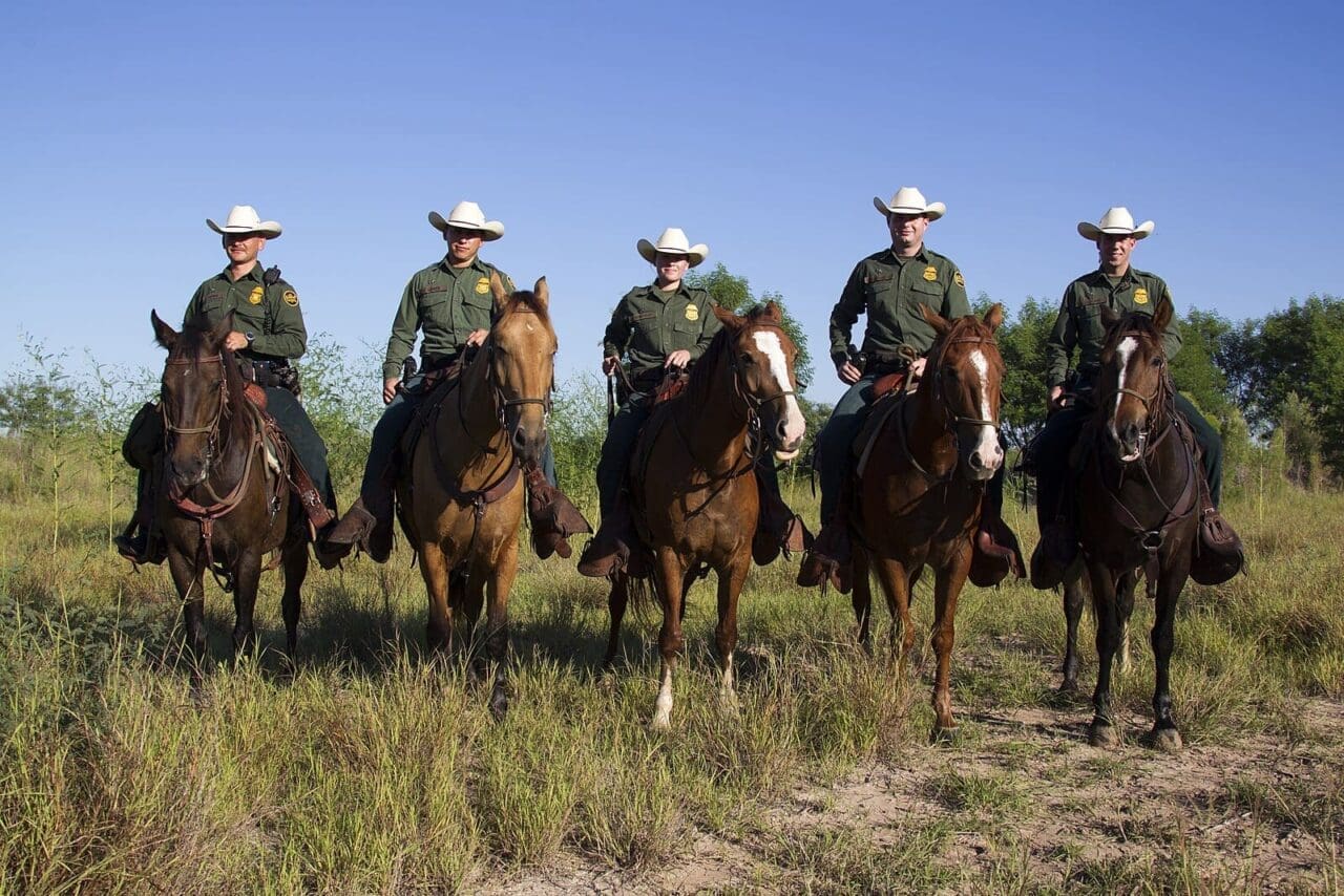 Texas border patrol agents on horseback, lined up for a photo.