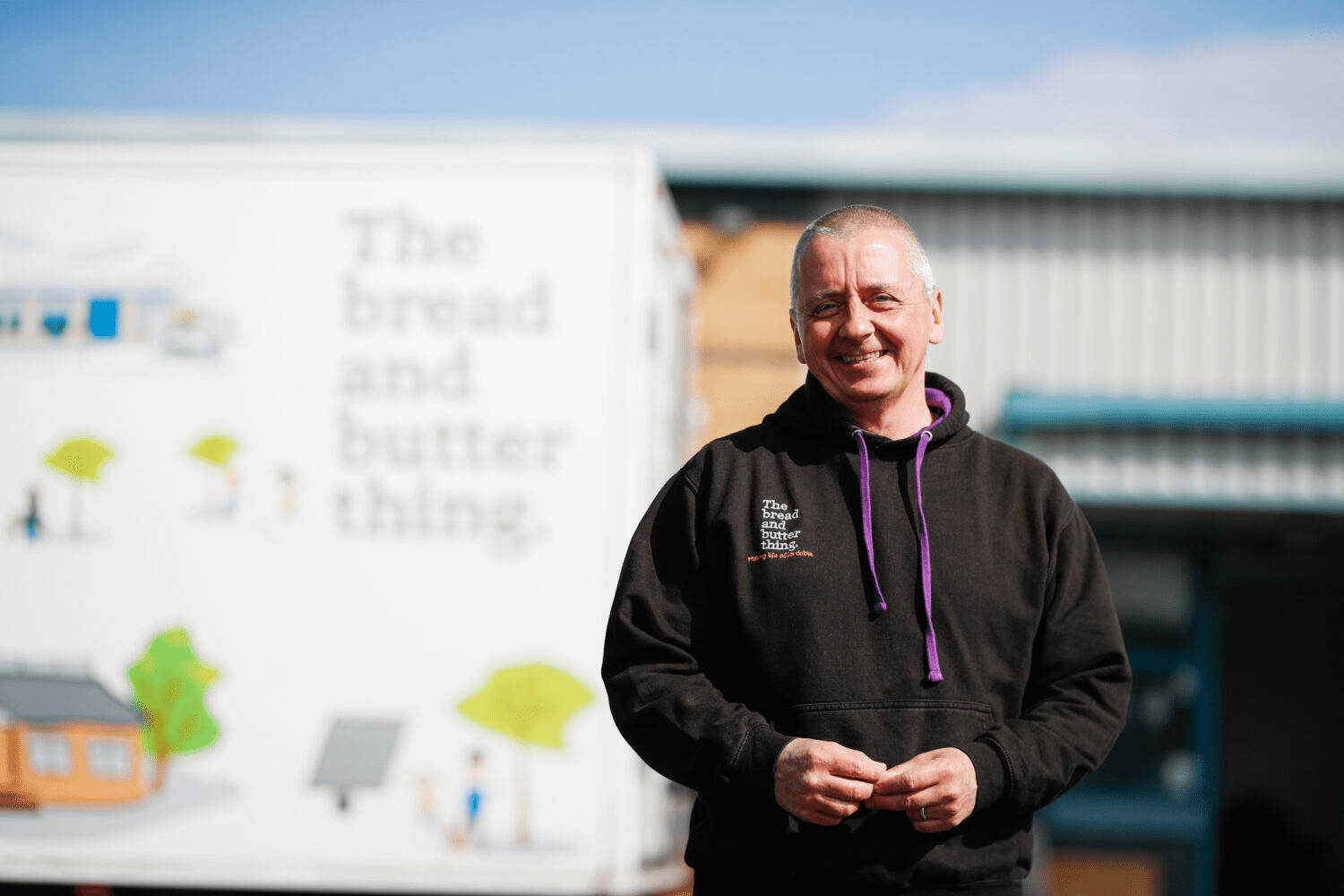 A food bank volunteer standing in front of the organization truck