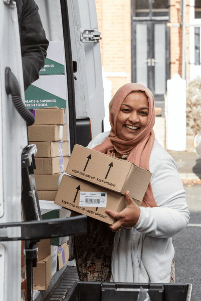 A food bank volunteer unloading boxes from a truck