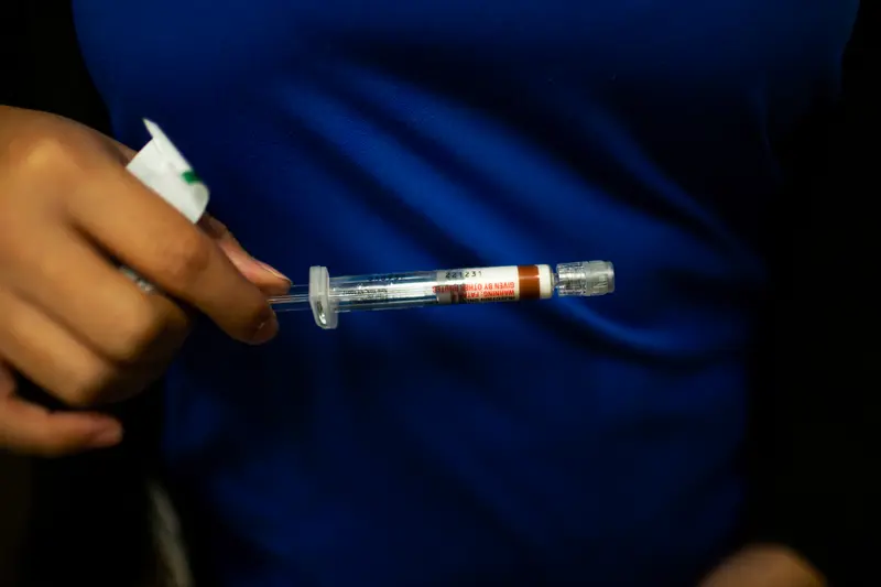 A medical assistant holding a syringe