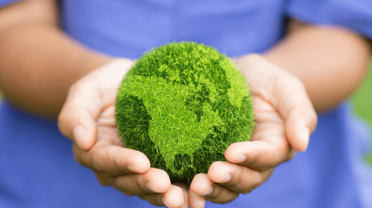 Mission statement. Hands holding a green planet earth made from plants.