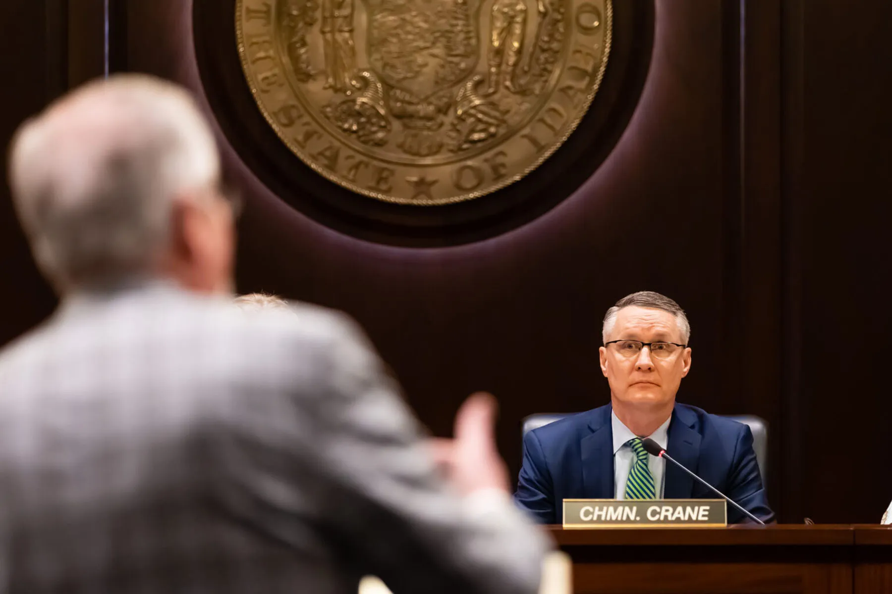 Idaho House State Affairs committee chairman Brent J. Crane, R-Nampa, listens to Rep. Bruce Skaug present before the committee at the State Capitol building.