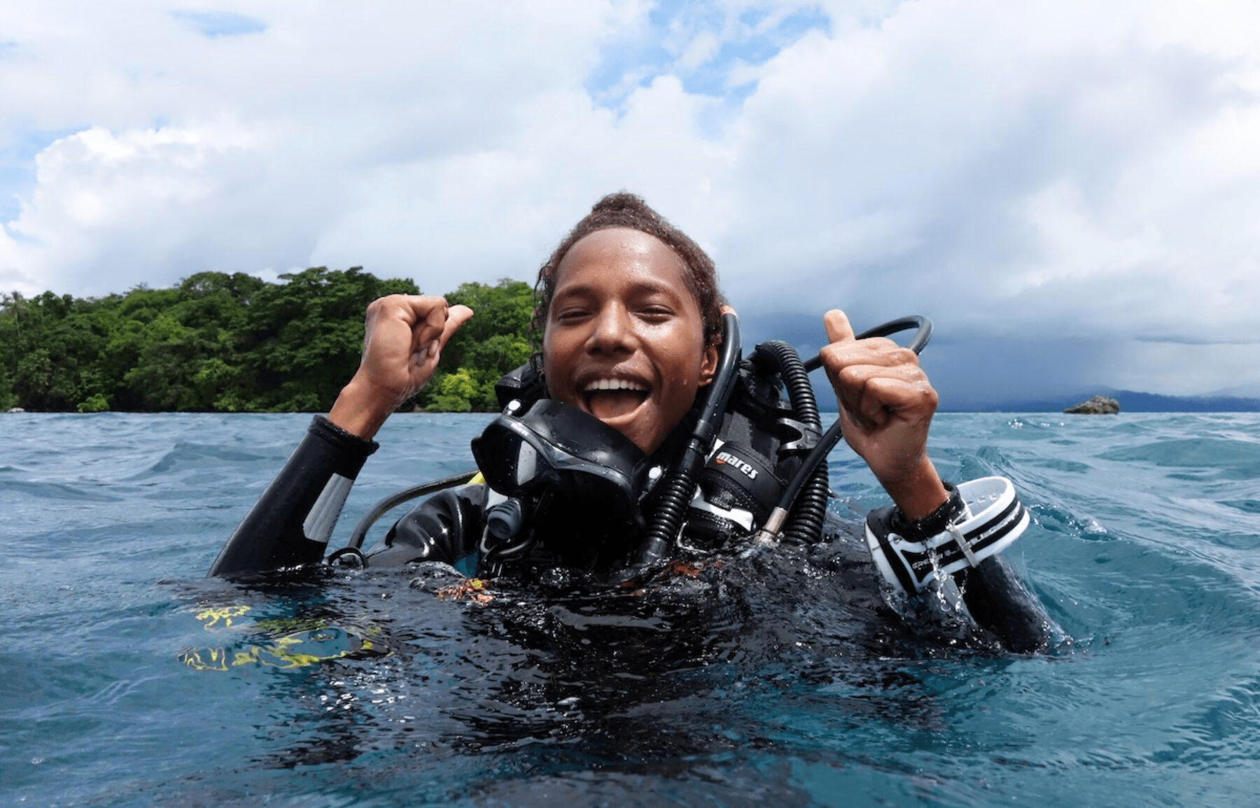 One of the Conservationists Naomi Longa
A  man in scuba gear coming up in the water smiling and cheering