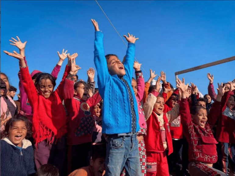 Children in gaza cheering with arms raised