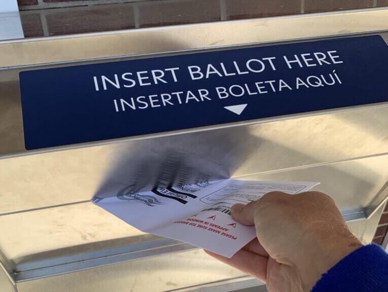 A voter returning a mail-in ballot