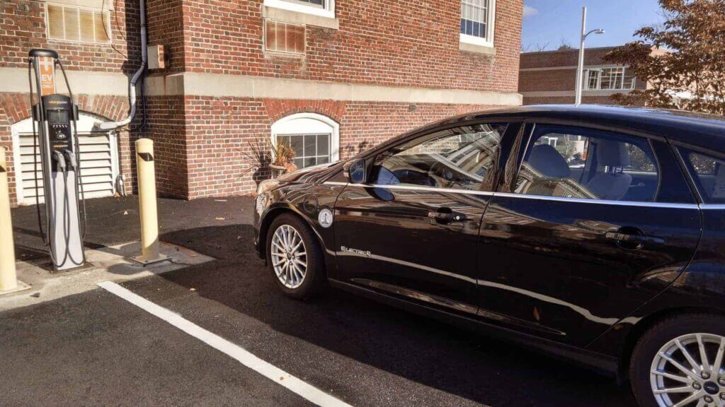 Electric vehicle parked at a charging station in a parking lot.