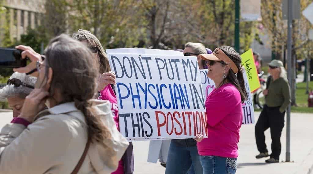 A protester at a planned parenthood great northwest rally in boise, idaho, holds up a sign about the emtala case on april 21, 2024.