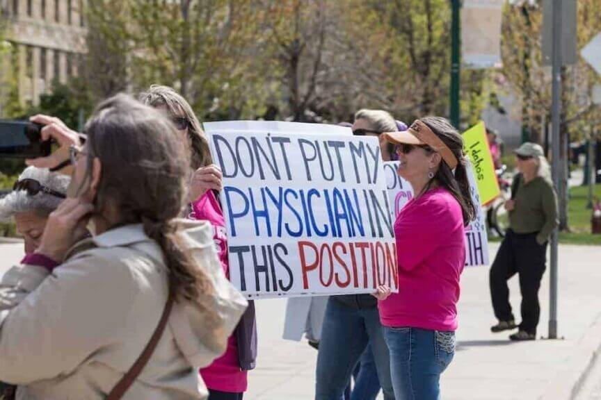 A protester at a planned parenthood great northwest rally in boise, idaho, holds up a sign about the emtala case on april 21, 2024.