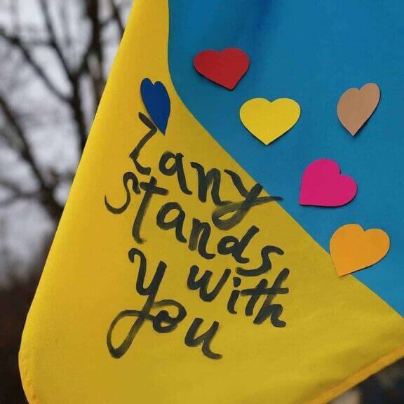 War in ukraine: ukranian flag with hearts and written in black marker: zany stands with you. ”