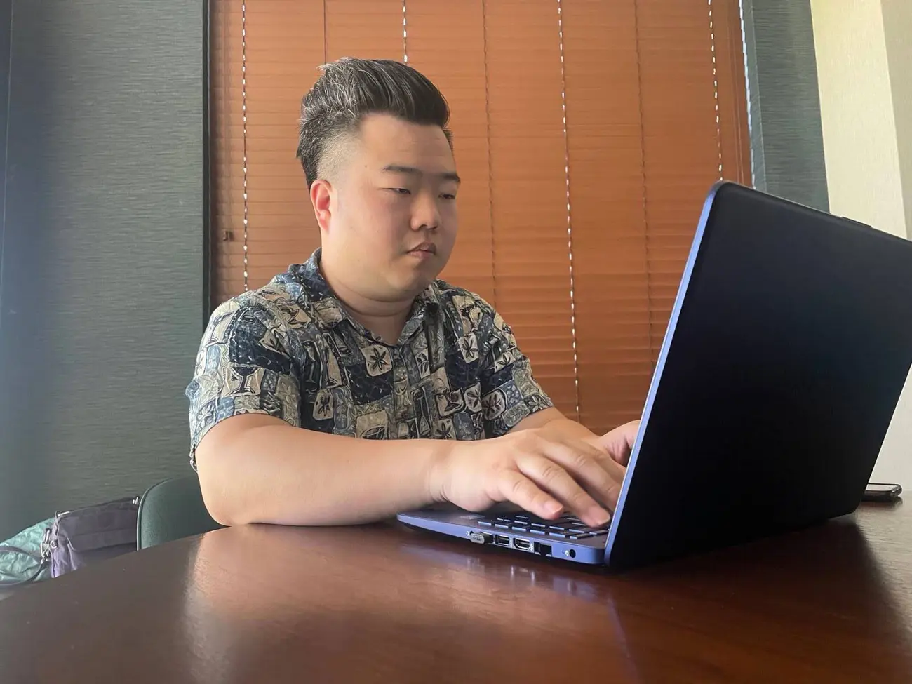 Westin zeng sitting at a desk on his laptop