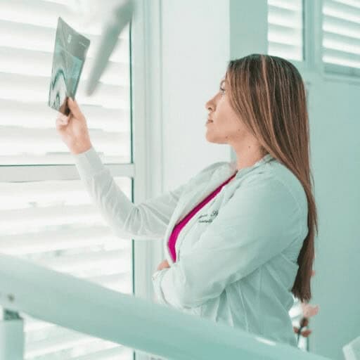 Good news doctor holds up x-rays at a sunny window to read them