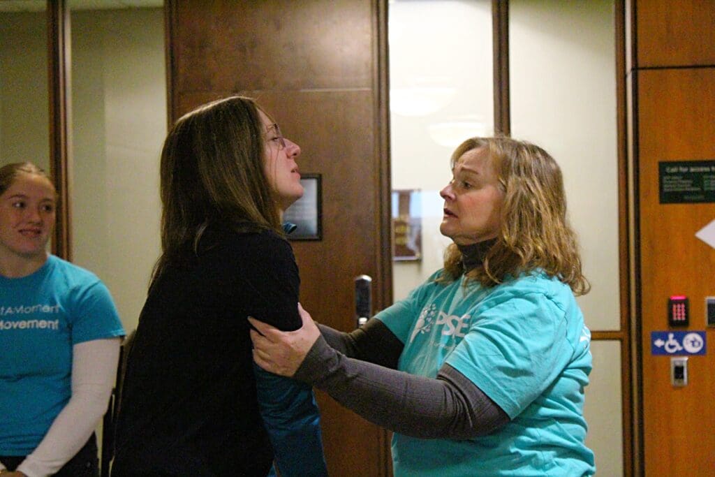 Valerie von Frank (right) offers support to Melissa Hudecz after Hudecz addresses the Michigan State University Board of Trustees on Dec. 15, 2023. 