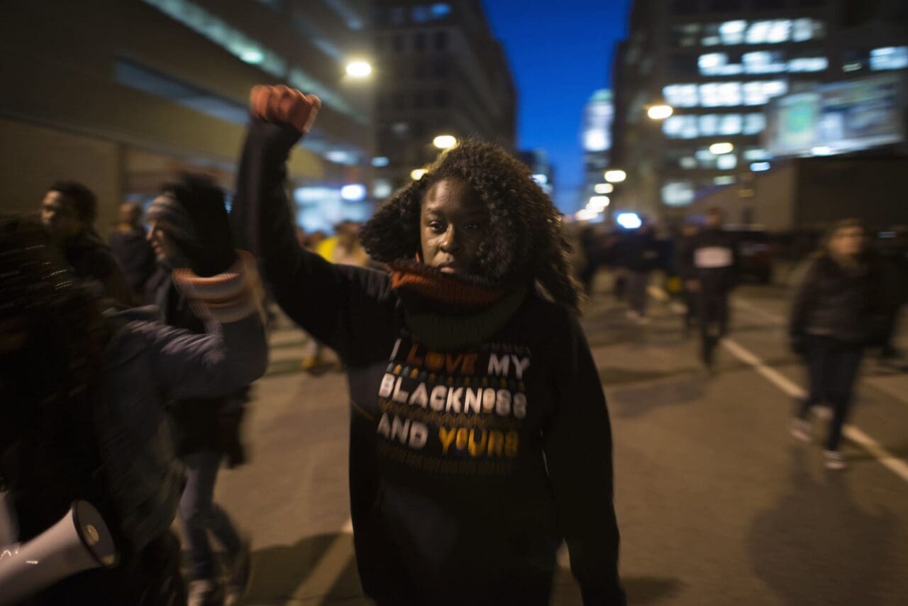 A Black Lives Matter protester in the street wearing a sweatshirt that says “I am proud of my Blackness and my values.”