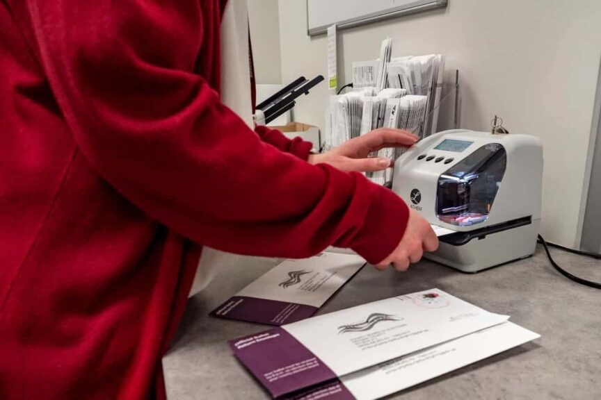An election worker in Snyder County stamps voters' mail ballots that have been returned in the 2024 primary election. A ruling by the state Supreme Court restored the requirement that mail voters write the date on their ballot envelope for the ballot to be counted.