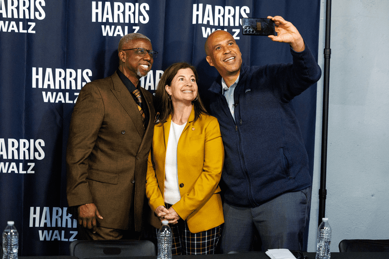 U.S. Sen. Cory Booker (D-N.J.), right, takes a selfie with Michigan state Sen. Kristen McDonald Rivet (D-Bay City), center, and Dwayne Clemons, left, after a roundtable with small business owners in Flint, Mich., on Sept. 20, 2024.