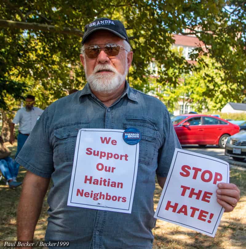 Racism in eating dogs trope: a man in springfield, ohio holds a sign that he respects and supports the haitian immigrants in town.