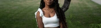 Black female college student posing in front of a tree