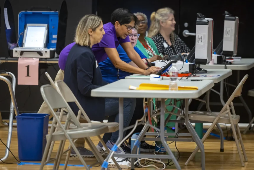 Presiding election judge dina patel, center, gives final instructions to election workers before polls open on election day at parker elementary in houston.