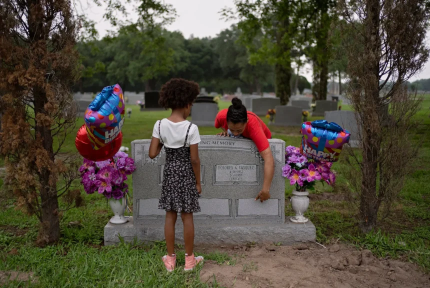 Raven hall, right, shows aminah anderson, 9, left, where anderson's father's name will be engraved on may 13, 2024 at the paradise funeral home and cemetery north in houston. Hall's brother and anderon's father, jaleen anderson, died while being held in lasalle correctional facility in louisiana.