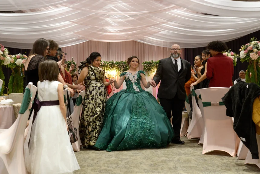 Guests stand and applaud as sienna raley, flanked by her parents maria and troy, begins the grand entrance at her quinceañera on dec. 16, 2023, in diboll.