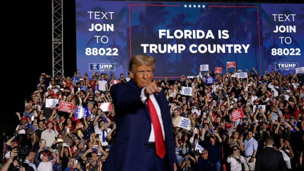 Elon musk is taking over while trump sits idly by. Donald trump pointing at supporters at a rally