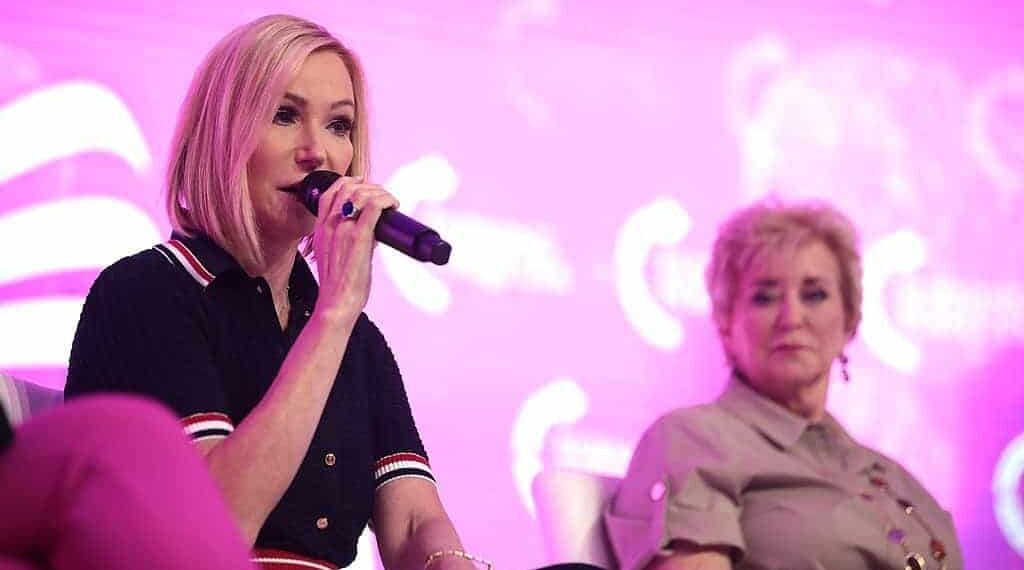 Pastor paula white speaks on stage with linda mcmahon.