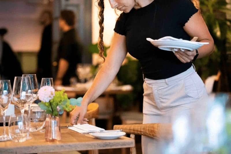 Home-kitchen waitress setting restaurant table