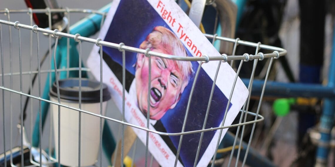Our president is a fascist a fight tyranny sign with a photo of donald trump in the basket on a bicycle