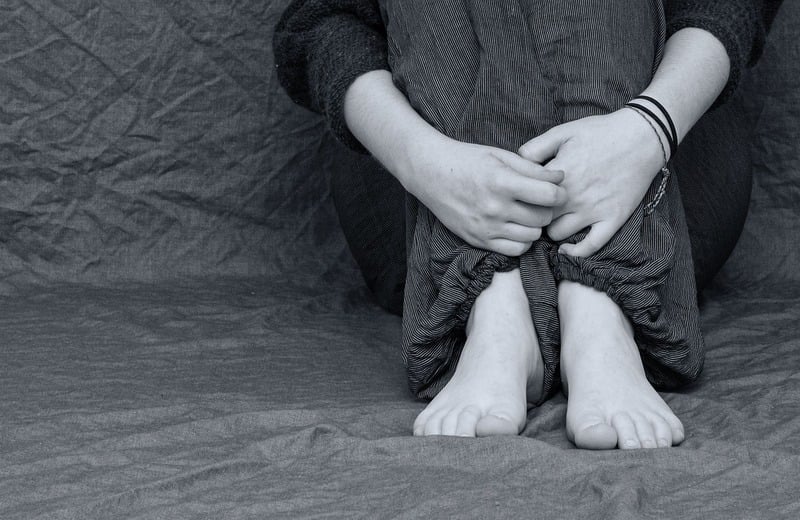 Ketamine treats people with major depressive disorder like this person, sitting on the floor with arms wrapped around their knees.