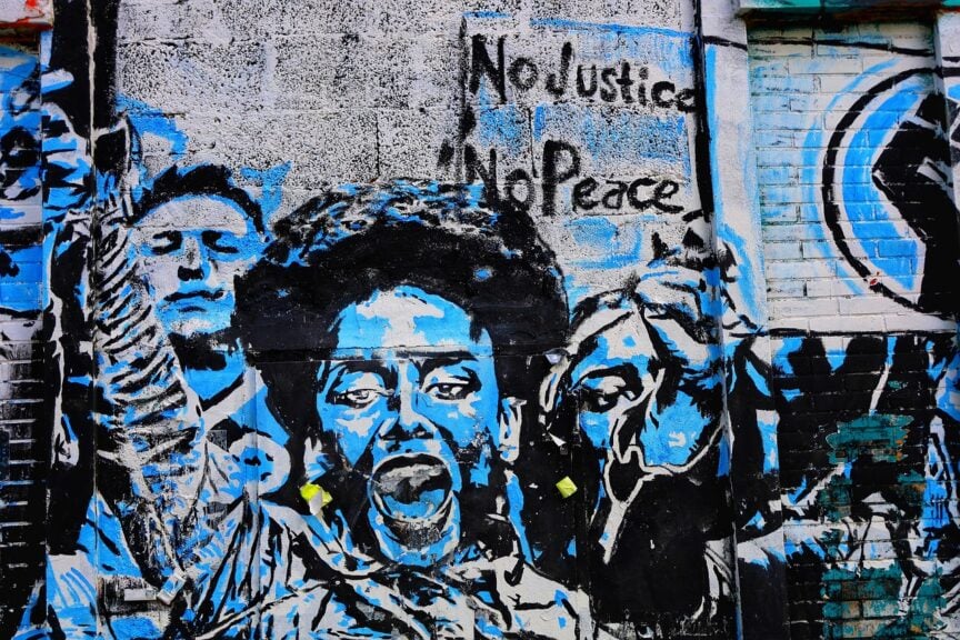 Social media vetting of student visa applicants began after student arrests for protesting. Urban art on a building of protesters.