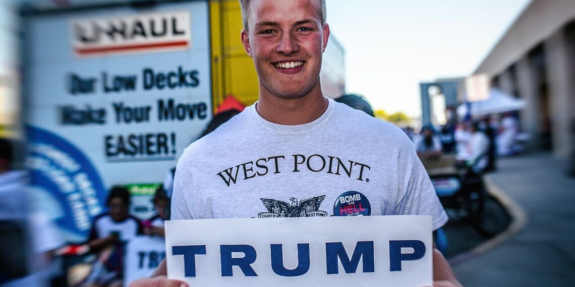 Donald trump at west point. A west point graduate holds a trump sign.