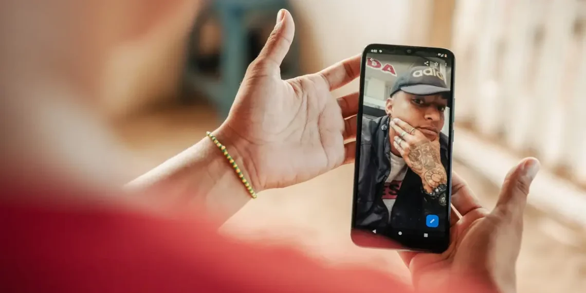 Woman holds a phone displaying a photo of her brother, now in the gulag in el salvador