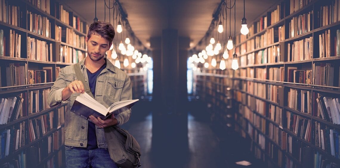 College student in a college library looking through a book