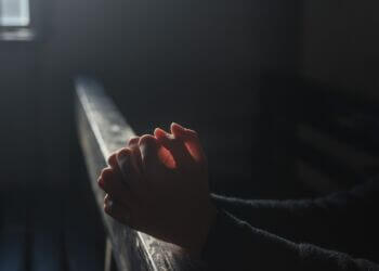 Hands in prayer at a church religious charter school